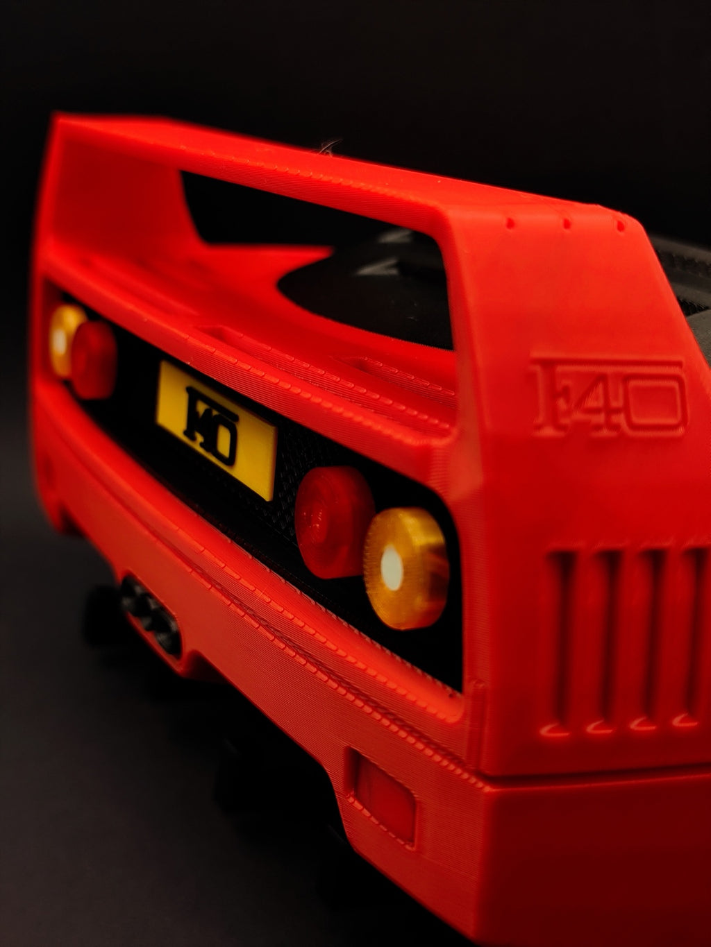 Close-up of red F40-inspired 3D printed key holder with rear light and grille details