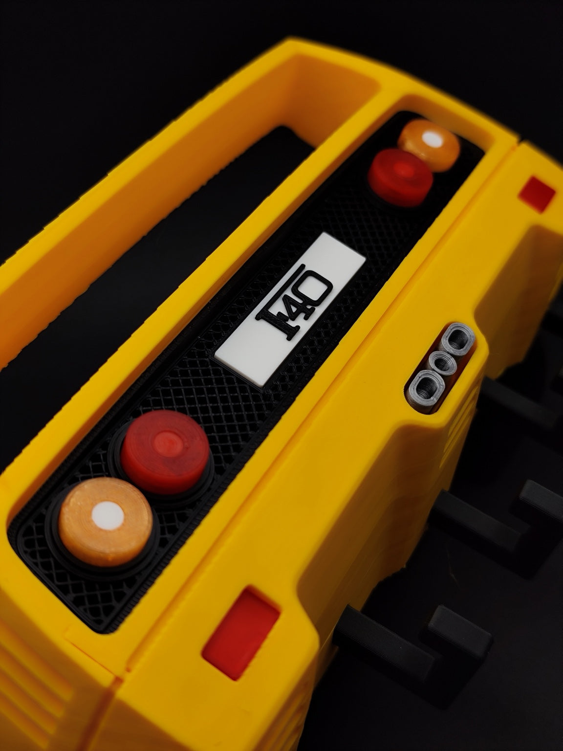 Close-up of yellow F40-inspired 3D printed key holder rear grille lights and exhaust details