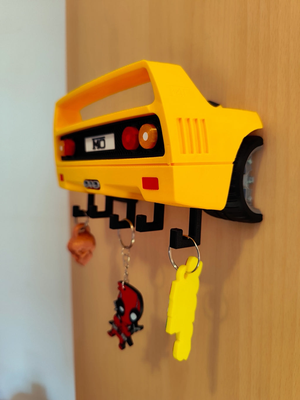 Yellow F40-inspired 3D printed automotive wall key holder mounted with keychains