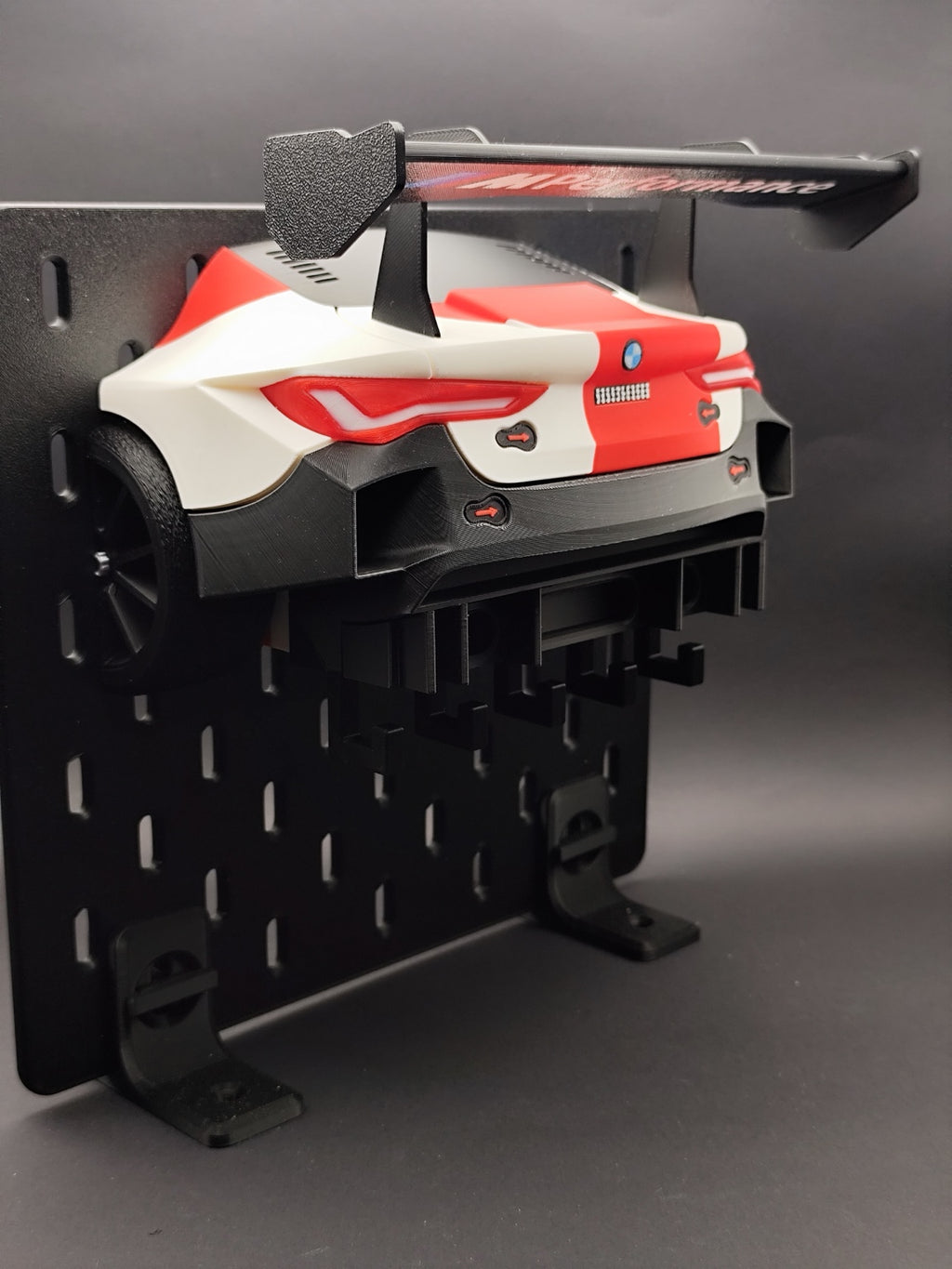 M4 GT3 key hanger displayed on a black pegboard with rear wing and five hooks