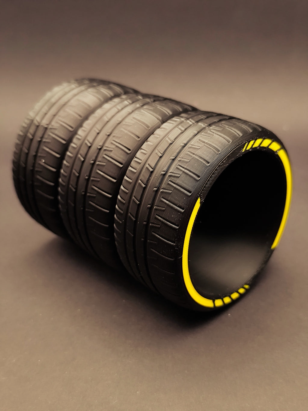 Side view of the stacked tire pen holder with realistic tread detail