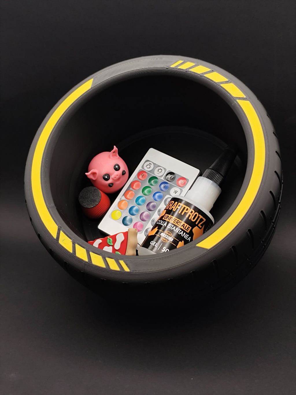 Top view of tire storage bowl holding small accessories against a dark background