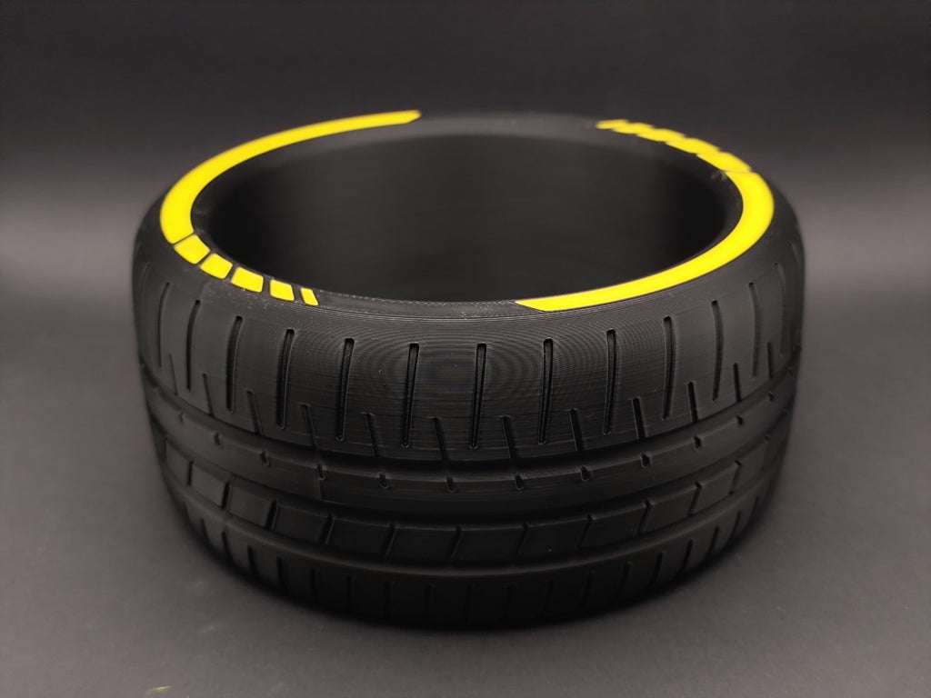 Empty tire catchall bowl showing tread detail and yellow rim accents