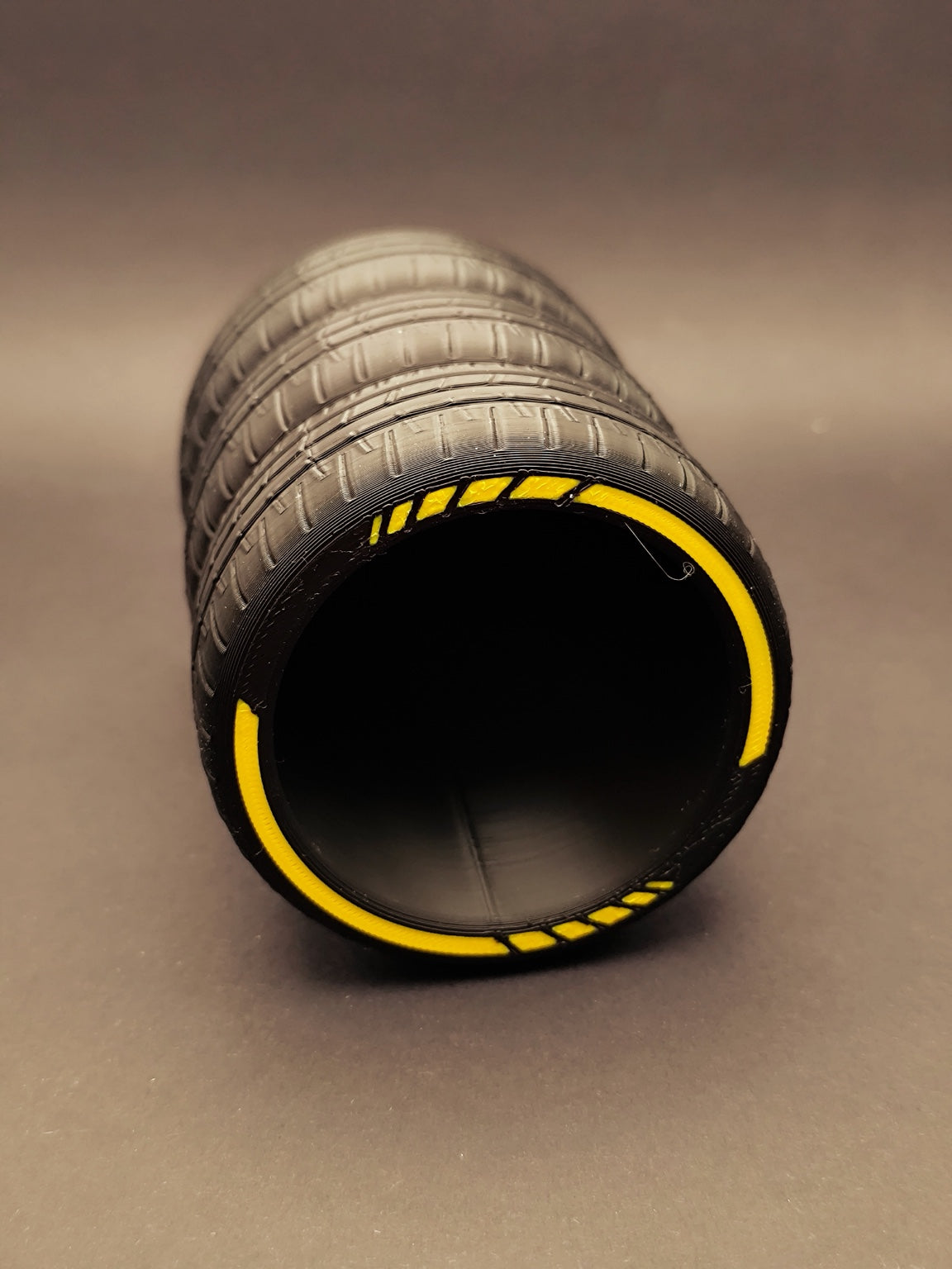 Stacked tire pen holder showing open interior and yellow rim accents